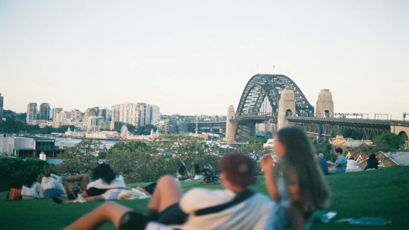 Couple relaxing near Sydney Harbour with the Sydney Harbour Bridge in the background