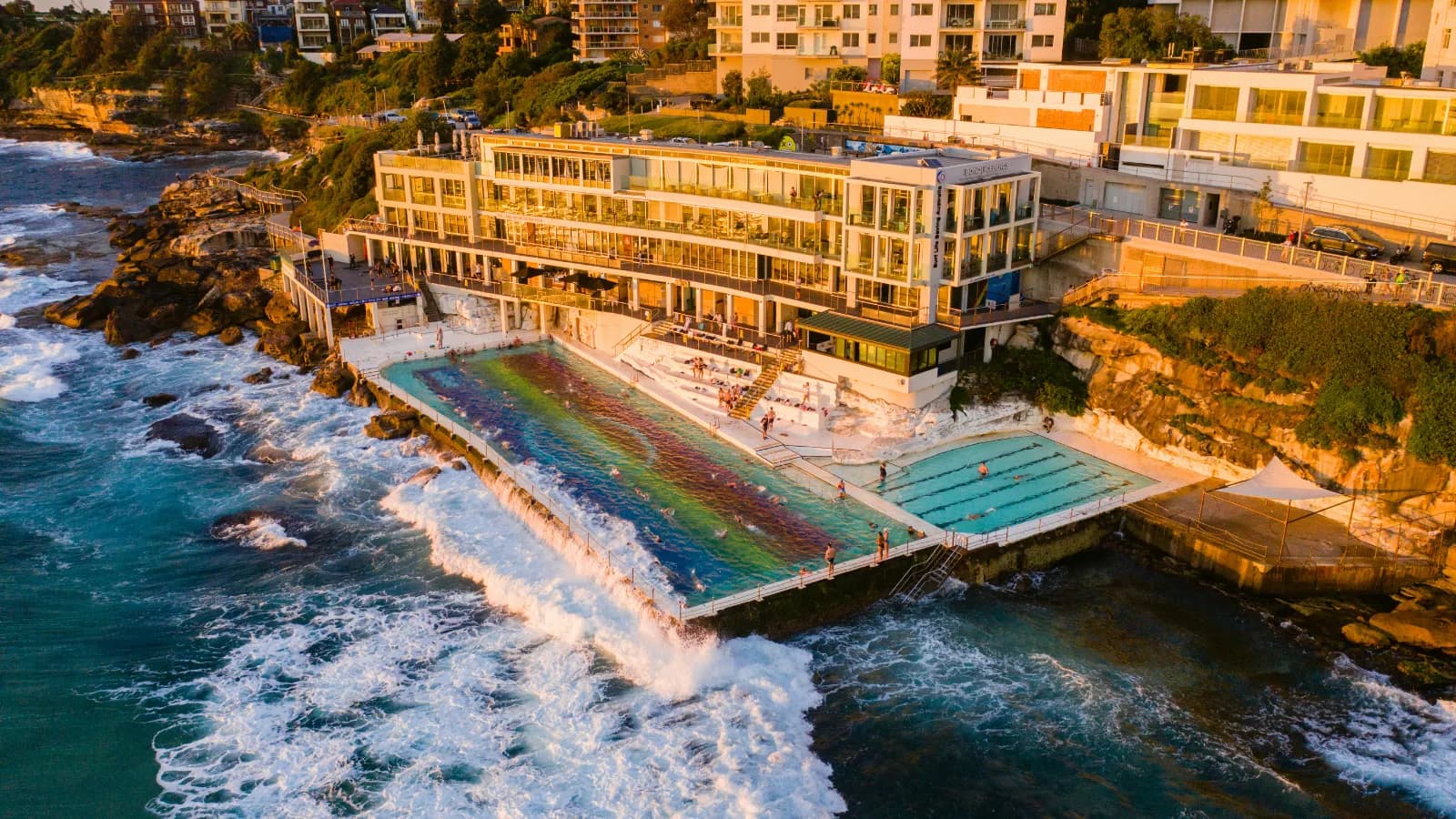 Bondi Icebergs pool, coastal apartments and sunset over Bondi in Sydney