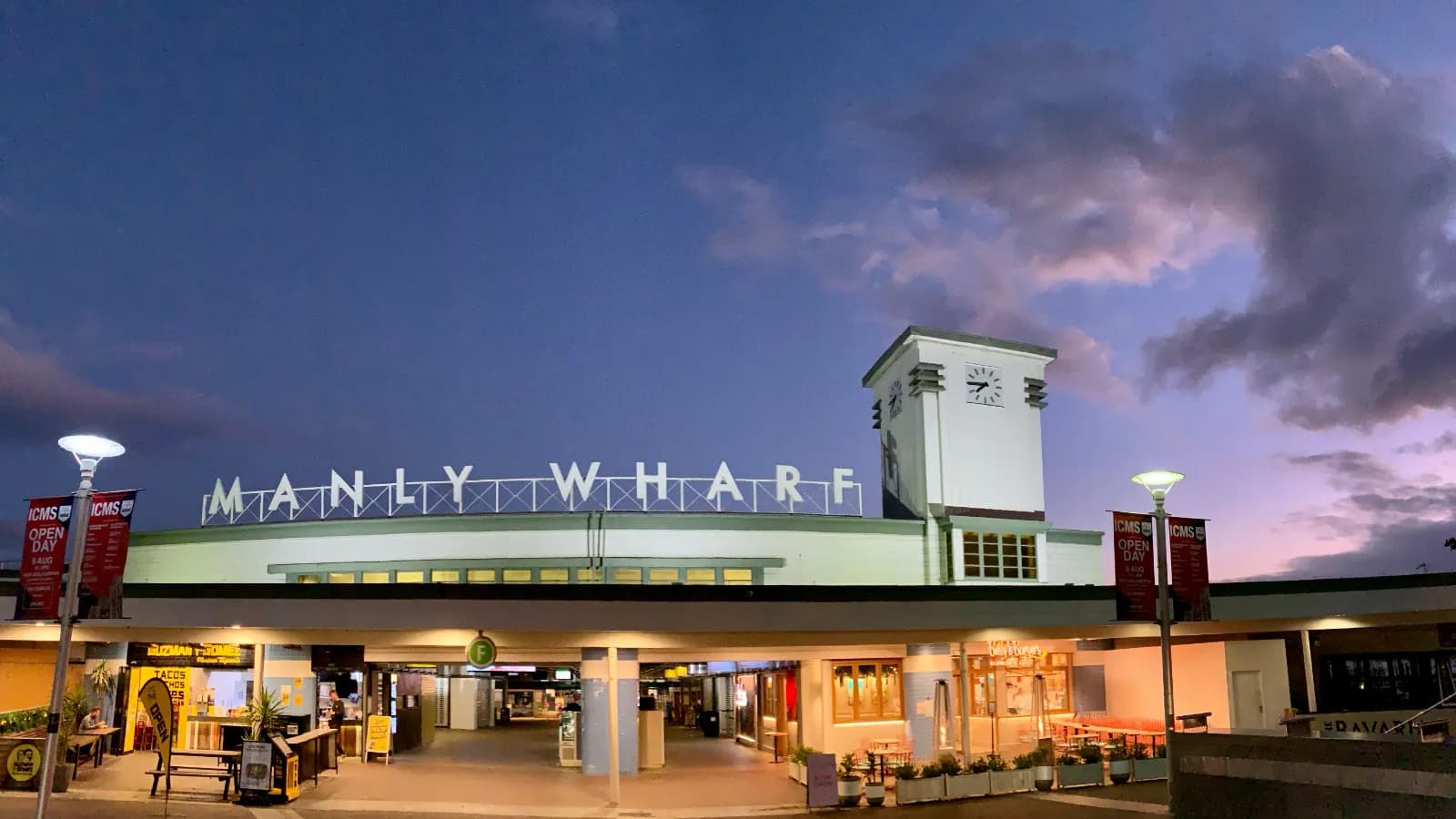 Manly Wharf illuminated in the evening under a colourful sky